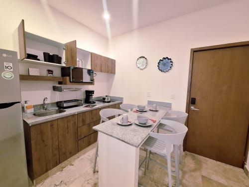 Modern kitchen and dining area in Itzamná Suite Deluxe at Playa del Carmen hotel with stainless appliances