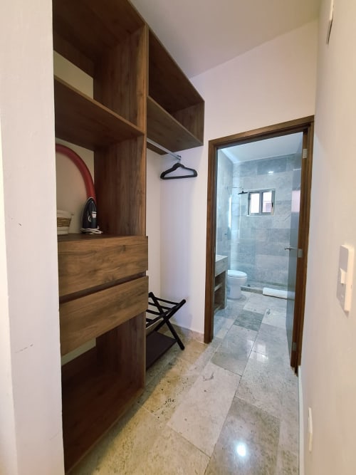 Modern ensuite bathroom in Itzamná Suite Deluxe, Playa del Carmen hotel with walk-in shower, toilet, and adjacent dressing