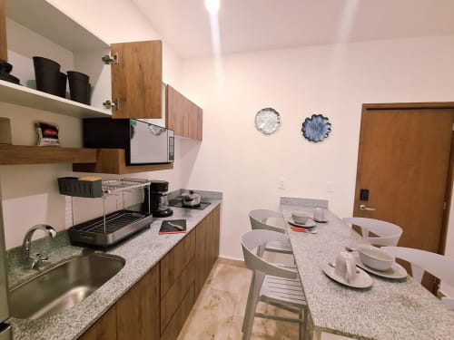 Modern kitchen and dining area in Itzamná Suite Deluxe at Playa del Carmen hotel with stainless appliances and granite