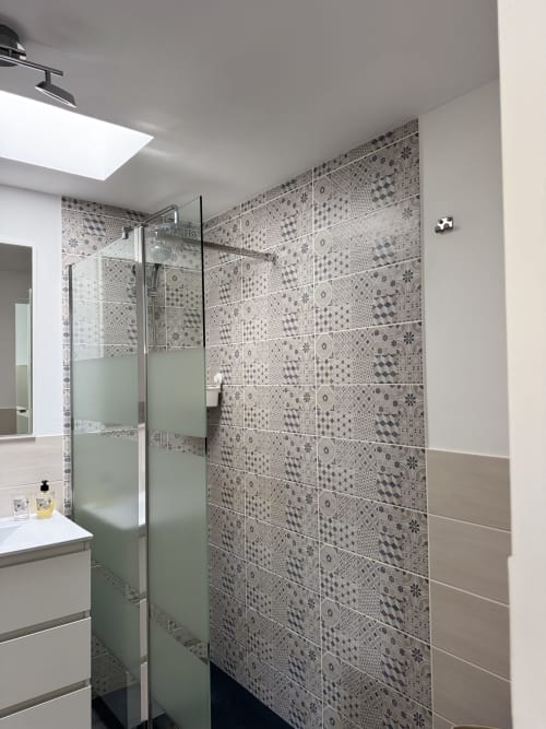 Baño moderno en Kamalahouse SL de Corralejo con plato de ducha de azulejos decorativos y paneles de cristal verde esmerilado