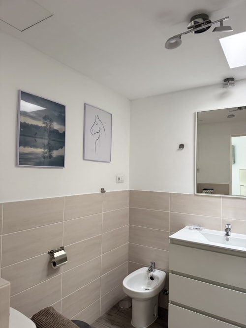 Baño moderno en apartamento Kamalahouse SL en Corralejo con azulejos beige, accesorios blancos y decoración minimalista