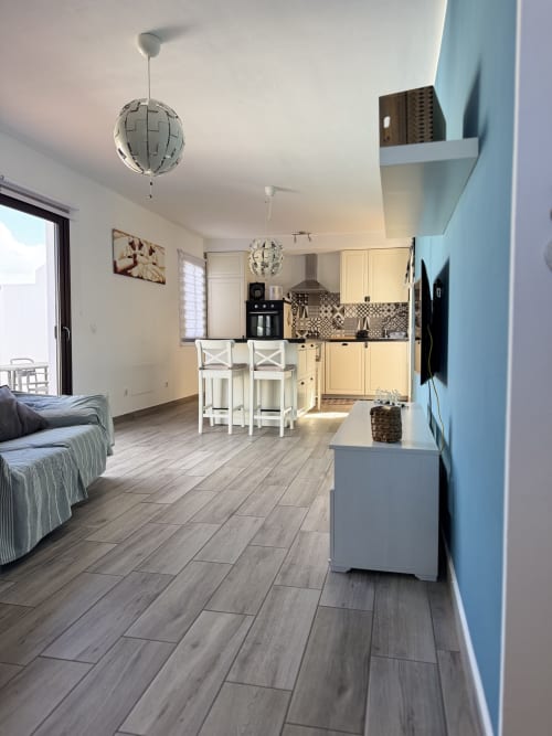 Moderno apartamento en Corralejo con cocina abierta, comedor y sala de estar con piso de madera clara