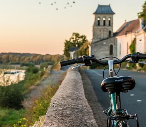 Bicycle parked on Loire Valley road overlooking church near Domaine Aurore de Beaufort, Saint-Martin-le-Beau