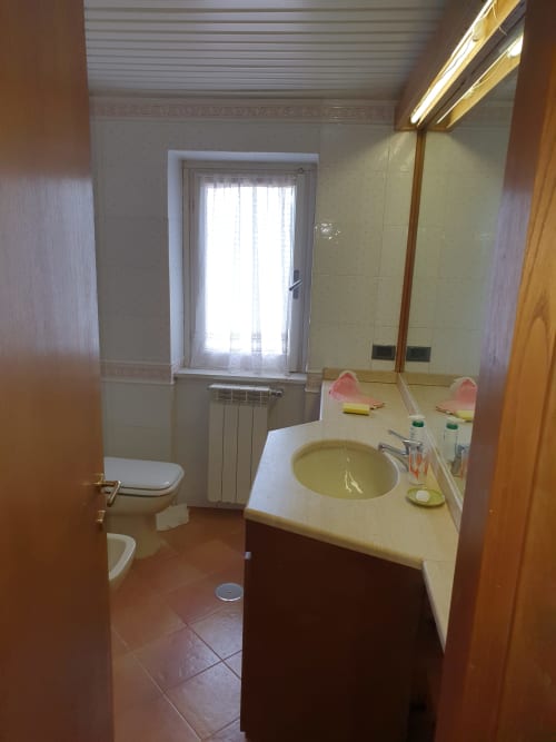 Moderno bagno in Altipiani di Arcinazzo Residence, Roma, con lavabo, toilette, specchio illuminato e finestra