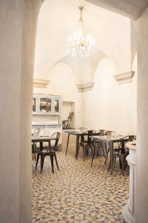 Elegante sala da pranzo della Locanda San Tomaso con soffitti a volta, lampadari e pavimentazione in piastrelle geometriche a Pietra Ligure