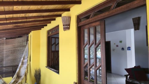 Exterior amarelo do apartamento Casa do Porto com vigas de madeira, portas e janelas de madeira escura com vista para o mar em Velha