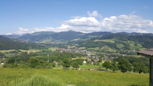 Vue panoramique de la vallée de Boëge avec collines verdoyantes, montagnes et villages pittoresques depuis Ô Panora'Gîte