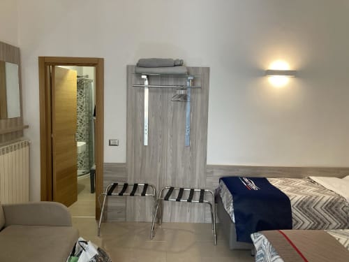 Stanza familiare presso 4STANZE B&B Napoli con letto, guardaroba, portabagagli e bagno privato