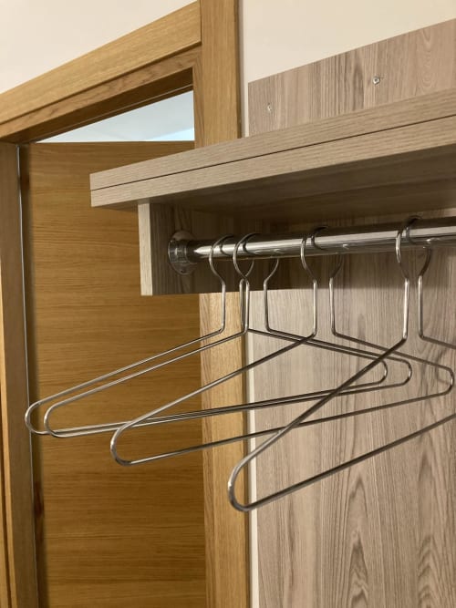Armadio in legno con grucce metalliche e asta nell'hotel 4STANZE di Napoli