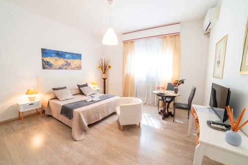 Bright bedroom with queen bed, work desk, and garden view at Belvedere del Lago, Montefiascone