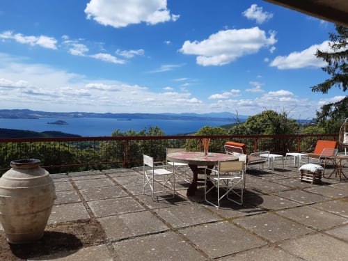 Belvedere del Lago terrace with lake view, dining table, and lounge chairs overlooking Montefiascone, Italy