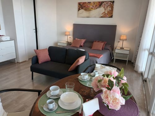 Peonia room at Belvedere del Lago, Montefiascone: black sofa, queen bed, pink flowers, lake view