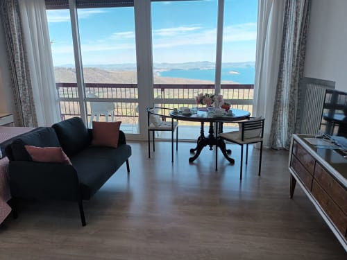 Peonia room at Belvedere del Lago with panoramic Lake Bolsena view from balcony, black sofa and dining table
