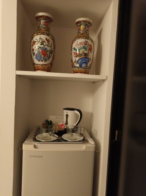 Decorated shelf with two ornate vases above mini fridge in Peonia room at Belvedere del Lago, Montefiascone