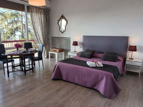 Giglio room at Belvedere del Lago: purple bedspread, lake-view balcony, modern furnishings, desk, lakeside setting in