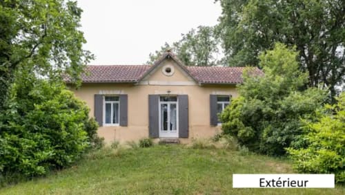Le Moulin de Bigorre, chaumière aux murs crème, volets et jardin luxuriant à Civrac-sur-Dordogne