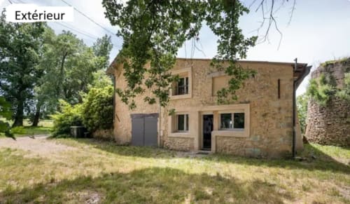 Maison en pierre Le Moulin de Bigorre avec vue sur le jardin à Civrac sur Dordogne, entourée d'arbres et de verdure
