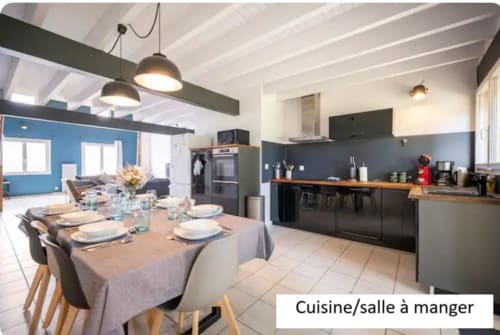 Cuisine-salle à manger moderne du gîte Le Moulin de Bigorre avec meubles noirs, comptoirs en bois et table dressée