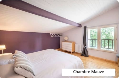 Chambre Mauve du Moulin de Bigorre : chambre avec mur d'accent violet, literie blanche, parquet et vue sur le jardin