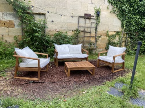 Mobilier de jardin en bois avec coussins blancs sur patio paillé à La Grande Mauvilla, Civrac sur Dordogne