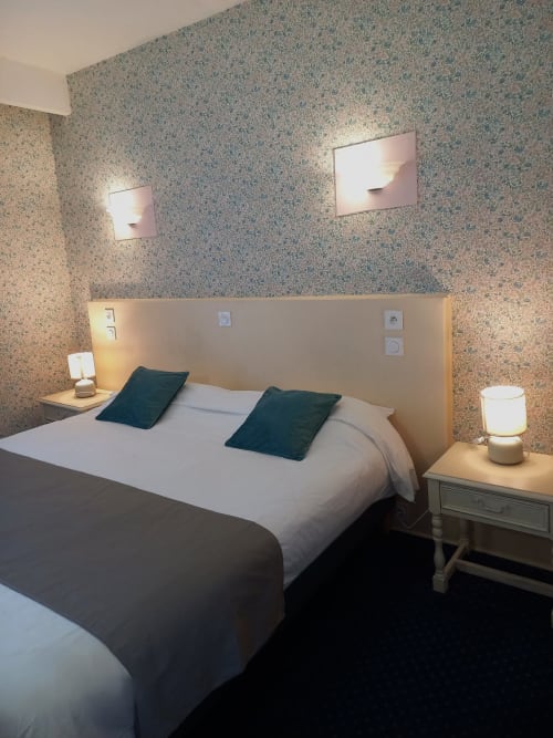 Chambre double plus at Hotel Le Centre, Les Herbiers with modern bed, dark pillows, bedside lamps, and textured wallpaper.