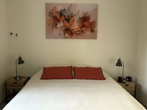 Chambre moderne au Jardin d'Elusa avec lit blanc, oreillers rouges, tables de nuit en bois et œuvre florale abstraite, Eauze
