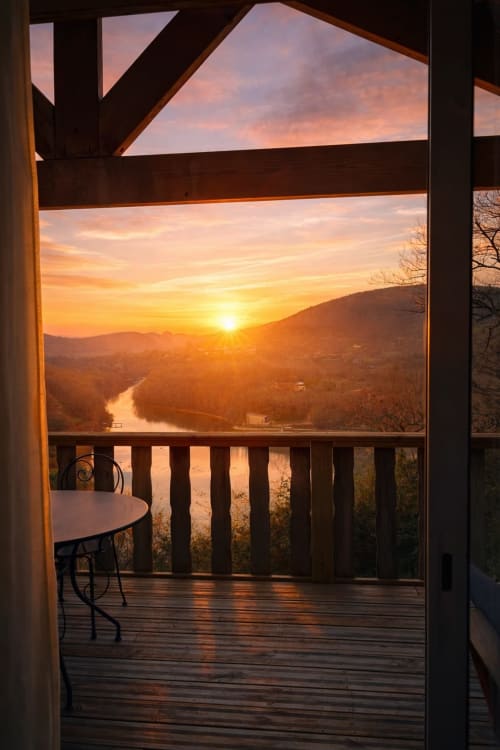 Vue coucher de soleil depuis la terrasse de la cabane surplombant la vallée de la rivière aux Cabanes et lodges du Belvédère, Serrières-sur-Ain