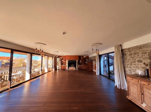 Spacious open-plan lounge at Hôtel de la Plage Wissant with wooden floors, large windows, and stone fireplace