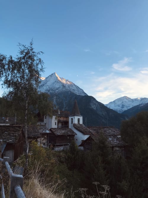 Alpine village church with snow-capped peaks, Hotel De La Sage, La Sage Switzerland