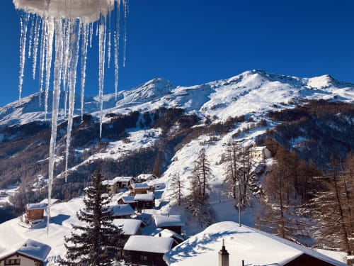 Village alpin enneigé avec chalets Hôtel De La Sage, pics montagneux et glaçons sous ciel bleu à La Sage, Suisse