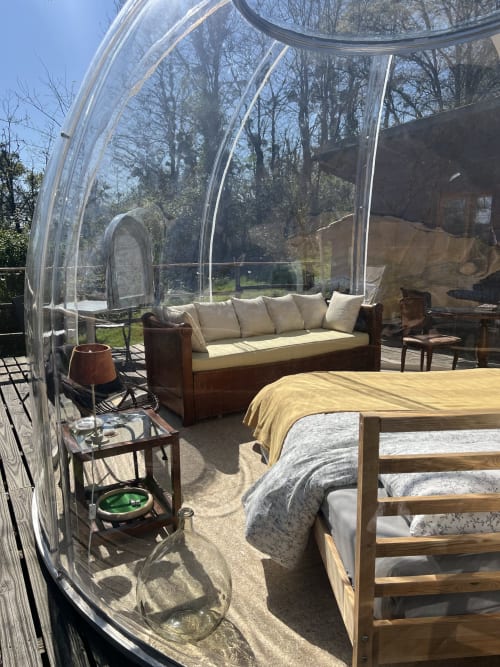La Bulle - chambre avec bulle au Domaine Des Laminak : lit, salon et vue sur le jardin à travers les murs transparents