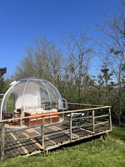 Bulle transparente du Domaine Des Laminak à Bidache avec terrasse en bois et vue sur le jardin