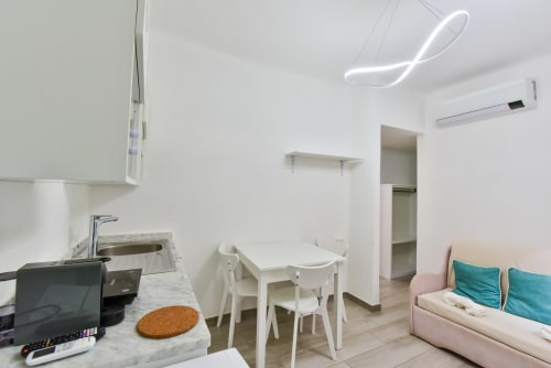 Moderno appartamento a Varigotti Fabio con angolo cottura, tavolo da pranzo, divano letto e illuminazione contemporanea