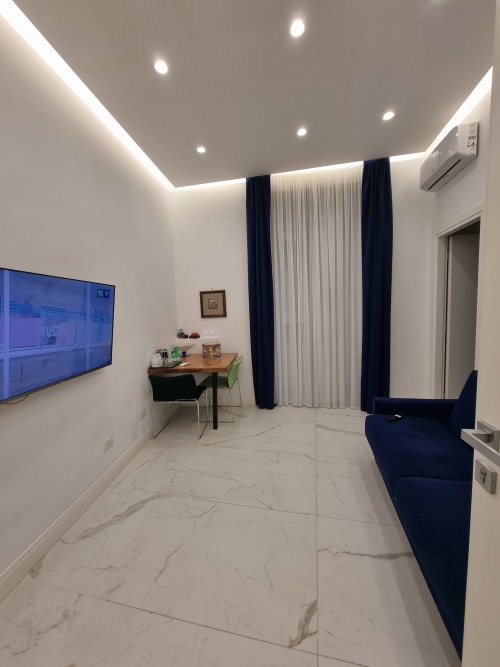 Suite Familiare Deluxe moderna al Relais Santa Lucia sul Mare di Napoli con pavimenti in marmo, accenti blu navy e design contemporaneo