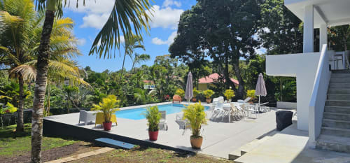 Poolbereich der Villa Les Cassias mit Liegestühlen, Sonnenschirmen und tropischen Gärten in Petit Bourg, Guadeloupe