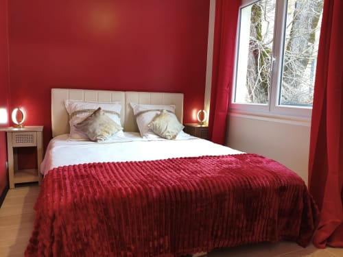 Chambre luxueuse rouge au Domaine du Vieux Tilleul à Meyrueis avec vue sur les montagnes par les grandes fenêtres