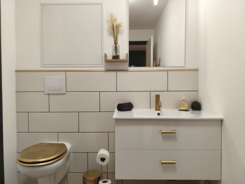 Salle de bain moderne au Domaine du Vieux Tilleul avec carrelage blanc, accessoires dorés et lavabo, Meyrueis