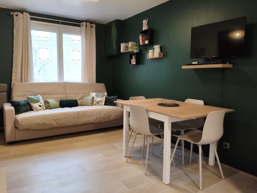Élégant séjour aux murs verts au Domaine du Vieux Tilleul, Meyrueis, avec canapé beige, table à manger et téléviseur
