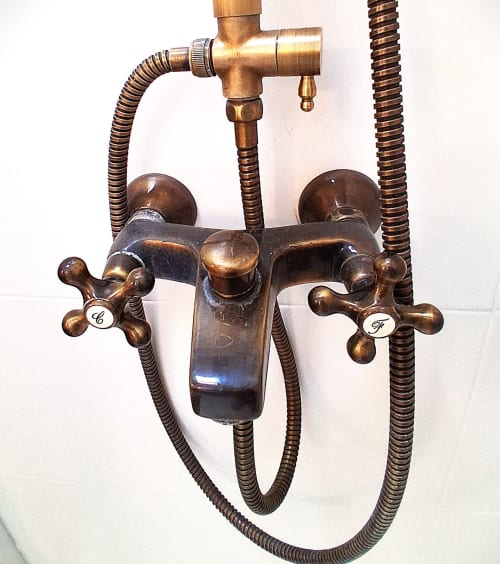 Grifo de ducha vintage en latón con manijas cruzadas y mangueras flexibles en RuralGorgs, casa rural en El Vilosell, España
