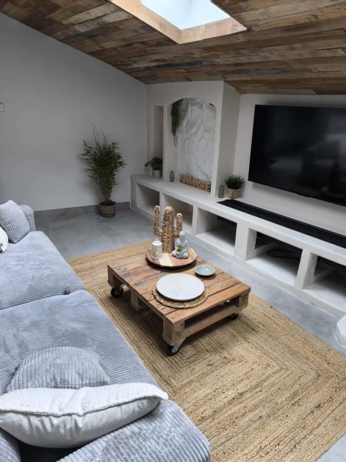 Salon moderne à l'Escale à Clisson avec canapé gris, téléviseur écran plat, plafond en bois et décoration naturelle