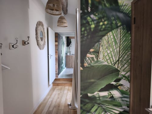 Couloir contemporain à Escale à Clisson avec luminaires suspendus tressés, miroir mural et vue sur la végétation tropicale des jardins de Bali