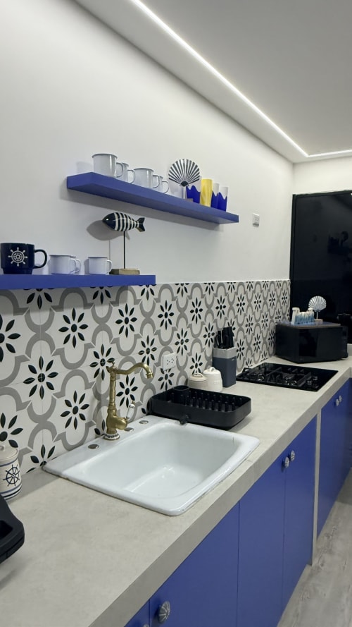 Cocina Nautilus Palace con estantes azules, azulejos estampados, fregadero blanco y decoración náutica en Madrid