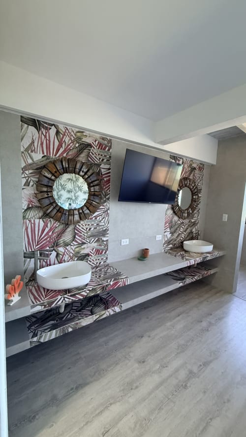 Baño moderno en apartamento Nautilus Palace de T-Homes Madrid, con dobles lavamanos blancos tipo vasija y papel tapiz tropical