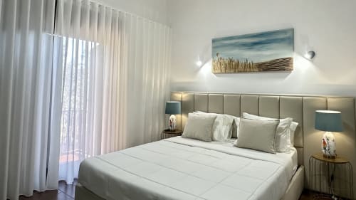 Quarto deluxe na Quinta das Susandas com cama branca, vista para o jardim, cabeceira elegante e acesso a varanda