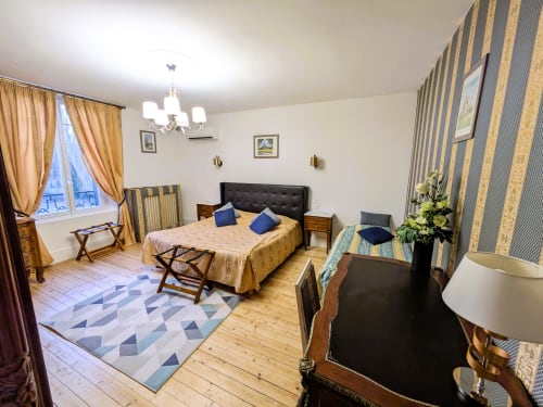 Chambre Azur du Château de Quesmy avec lit queen-size, rideaux rayés et vue sur le jardin