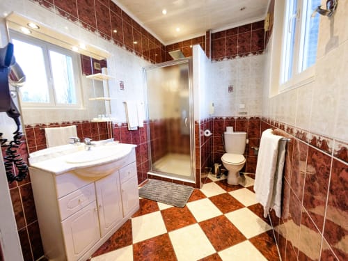 Salle de bain élégante de la Chambre Rubis au Chateau de Quesmy, carrelage rouge et crème, vanité et douche