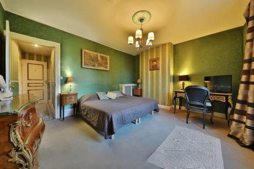 Emeraude bedroom at Chateau de Quesmy, elegant green room with bed, garden view and modern amenities