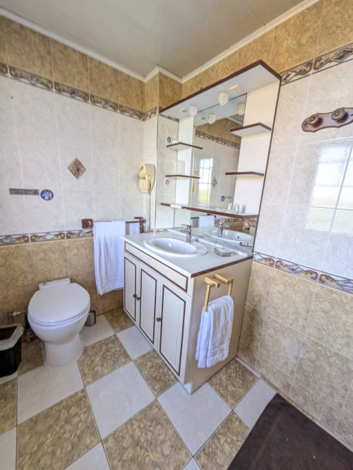 Salle de bains élégante dans la Chambre Topaze du Château de Quesmy avec double vasque, carrelage marbre et équipements modernes