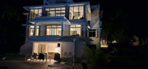 Moderne Villa bei Nacht mit beleuchteten Fenstern, Terrassenbestuhlung und tropischen Pflanzen in der Habitation Villa Les Cassias