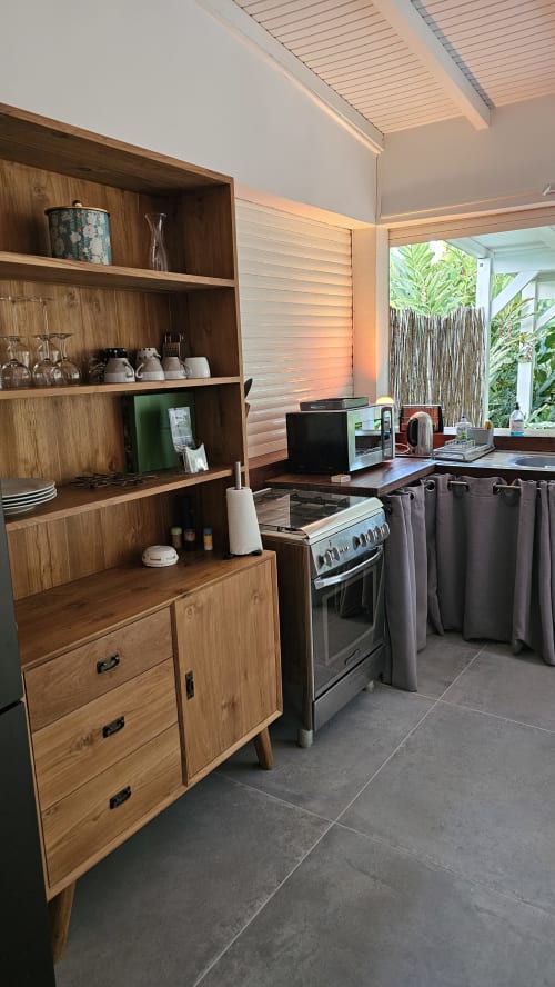 Moderner Küchenbereich in der Villa Les Cassias mit Holzschränken, Edelstahlherd und Außenbereich